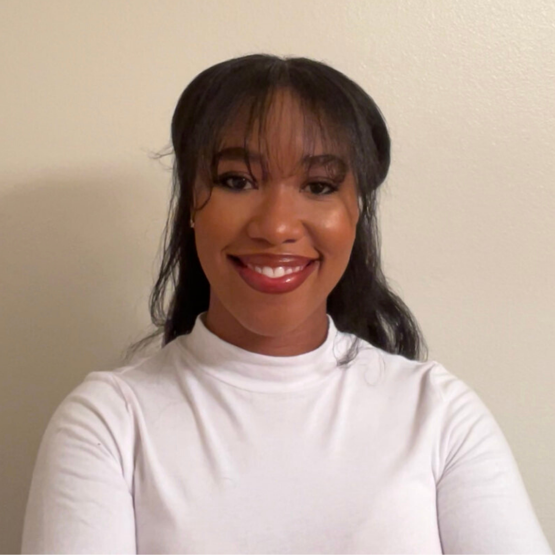 Alexandria Bingham wear a white turtleneck and smiles to the camera.